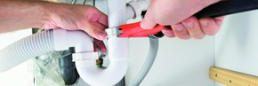 Handwerker repariert eine Sanitärleitung unter dem Waschbecken